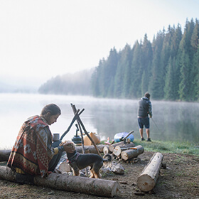People fishing with their dog on the shore